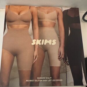 SKIMS Seamless Sculpt Mid Waist Shorts left leg exposed - Clay